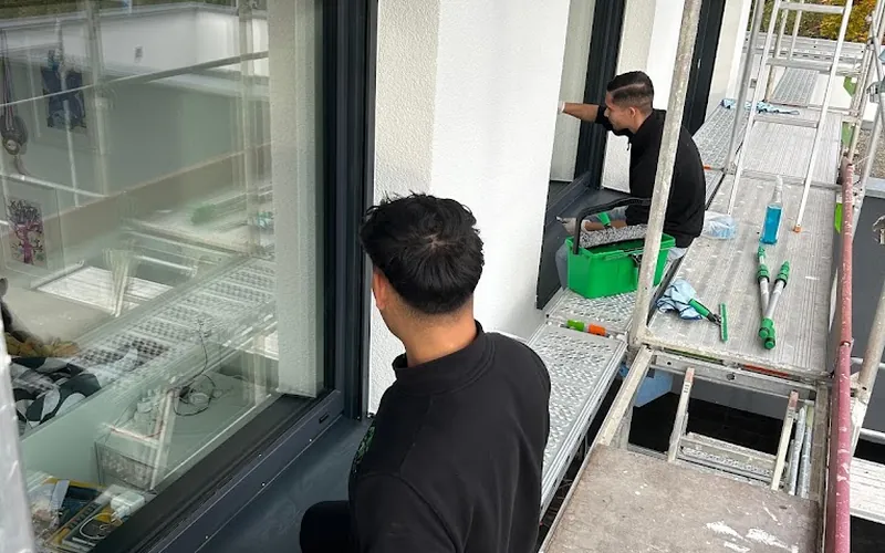 Team von Blitz & Blank bei der Fensterreinigung auf einem Baugerüst